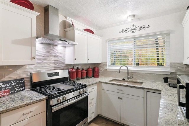 kitchen with white cabinetry, sink, wall chimney exhaust hood, light stone countertops, and stainless steel gas range oven