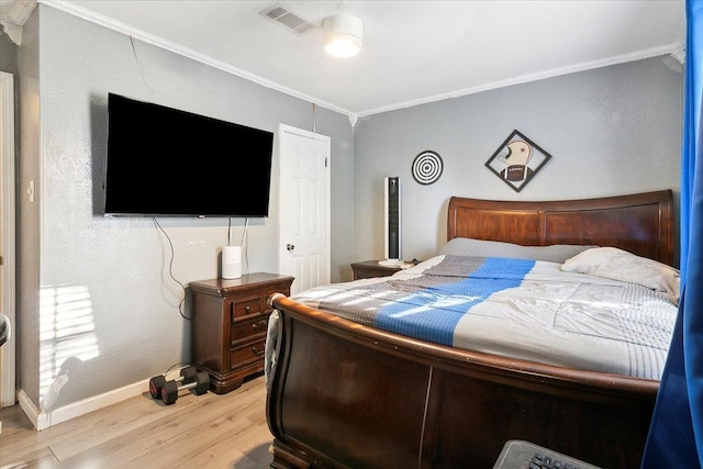 bedroom featuring light hardwood / wood-style floors and crown molding