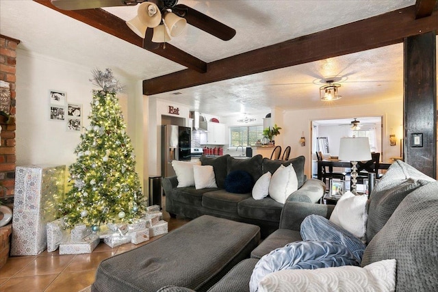 living room featuring sink, ceiling fan, dark tile patterned floors, a textured ceiling, and beamed ceiling