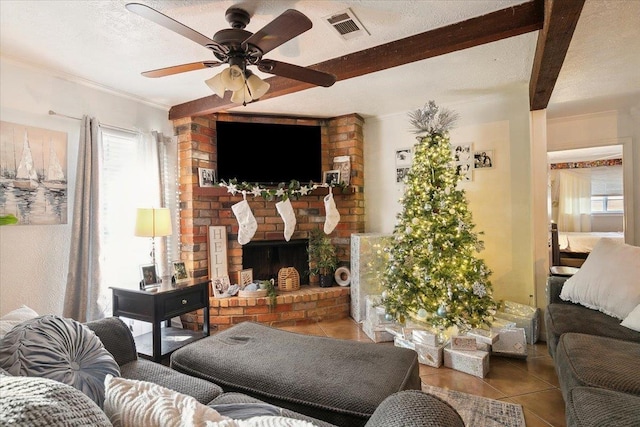 living room with beam ceiling, ceiling fan, a textured ceiling, a fireplace, and light tile patterned flooring