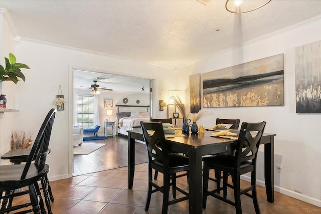 tiled dining room featuring ceiling fan, ornamental molding, and a textured ceiling