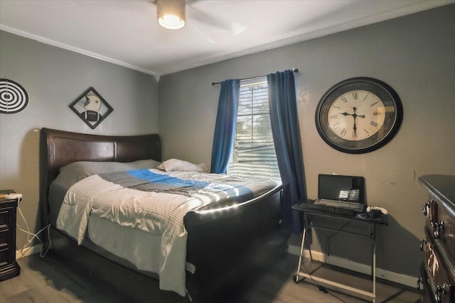 bedroom featuring hardwood / wood-style floors, ceiling fan, and ornamental molding