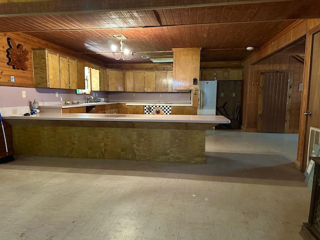 kitchen with kitchen peninsula, refrigerator, wooden walls, and wood ceiling