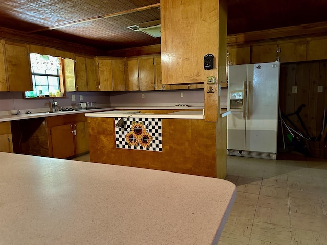 kitchen featuring white fridge with ice dispenser, sink, and wooden ceiling