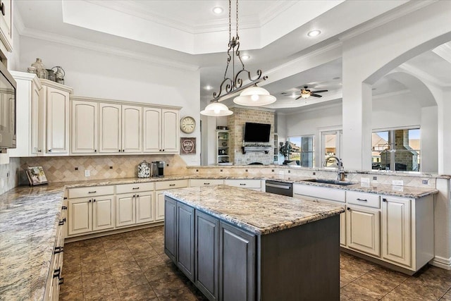 kitchen with a raised ceiling, sink, ceiling fan, tasteful backsplash, and kitchen peninsula