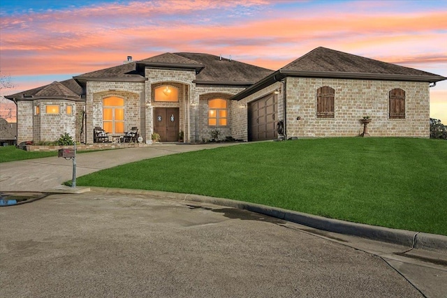 view of front of house featuring a yard and a garage