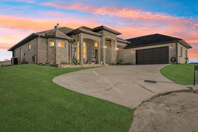 prairie-style house featuring a yard, cooling unit, and a garage