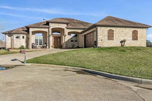 view of front of property featuring a garage and a front lawn