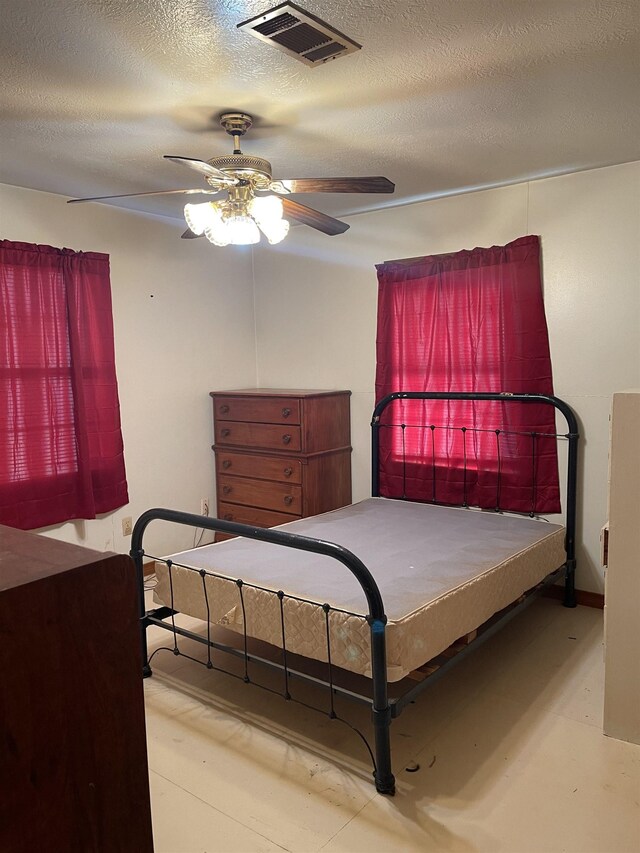 bedroom featuring ceiling fan and a textured ceiling