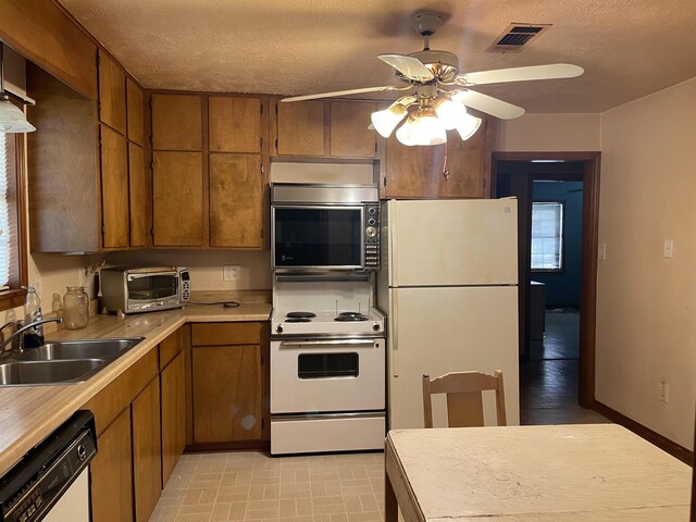 kitchen with a textured ceiling, ceiling fan, white appliances, and sink