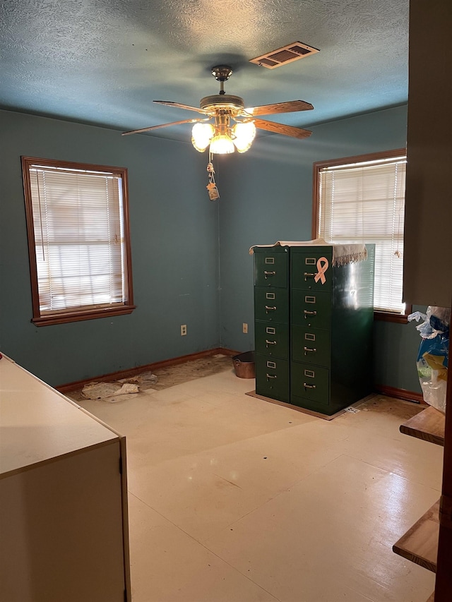 unfurnished bedroom with ceiling fan and a textured ceiling