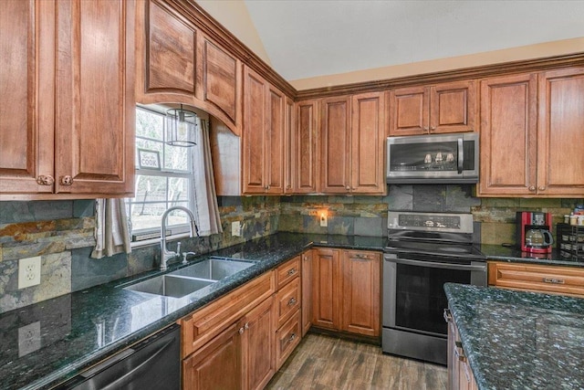 kitchen featuring tasteful backsplash, appliances with stainless steel finishes, sink, and lofted ceiling