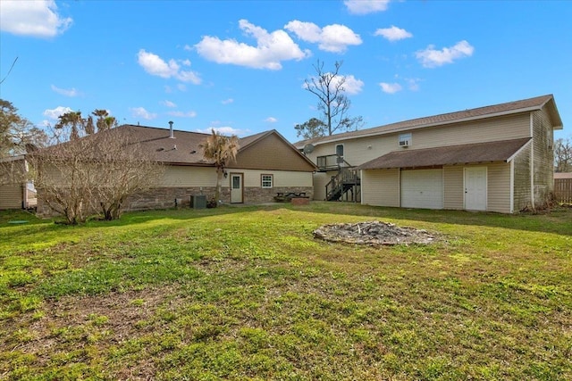 rear view of property featuring a garage and a yard