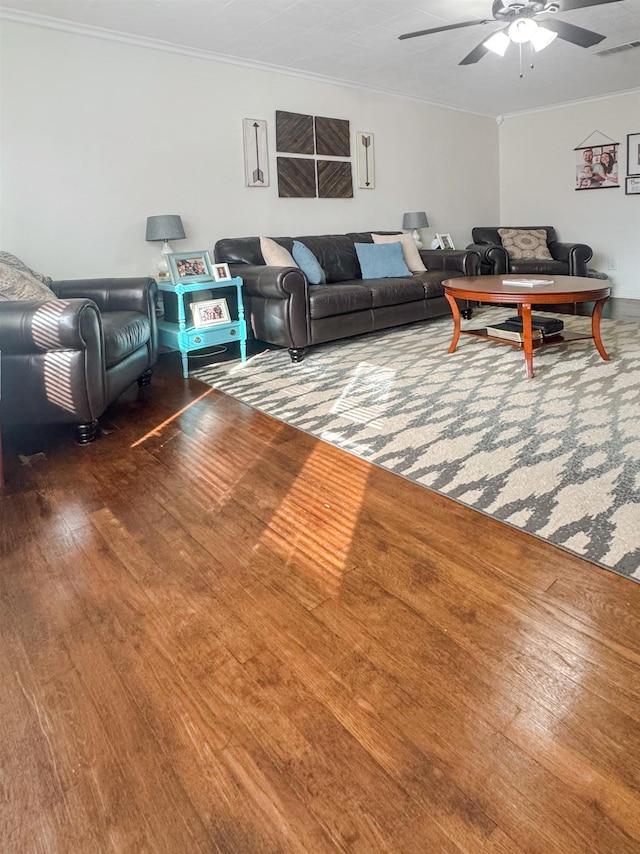 living room featuring hardwood / wood-style flooring, ornamental molding, and ceiling fan