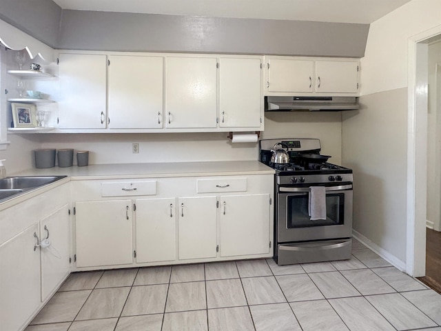 kitchen with stainless steel gas range, sink, and white cabinets