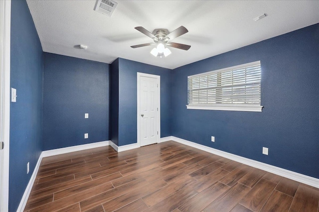 unfurnished bedroom with ceiling fan, wood finished floors, visible vents, and baseboards