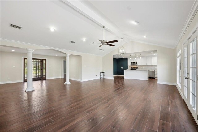 unfurnished living room featuring visible vents, dark wood-type flooring, lofted ceiling with beams, decorative columns, and baseboards