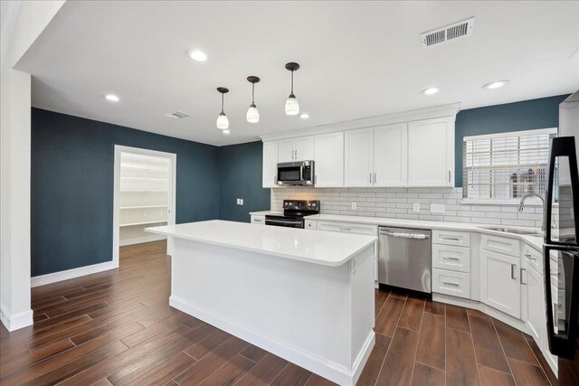 kitchen featuring a sink, dark wood-style floors, visible vents, and stainless steel appliances