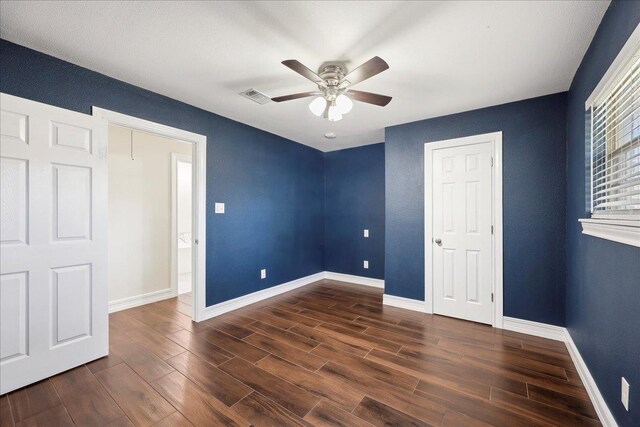 unfurnished bedroom with dark wood finished floors, visible vents, ceiling fan, and baseboards