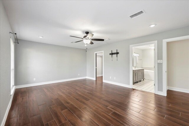 empty room featuring visible vents, baseboards, dark wood-type flooring, and ceiling fan