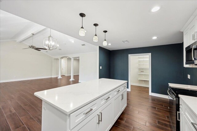 kitchen with electric range, stainless steel microwave, dark wood finished floors, arched walkways, and baseboards