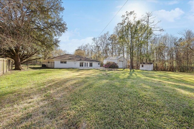 view of yard featuring an outdoor structure, a storage shed, and a fenced backyard