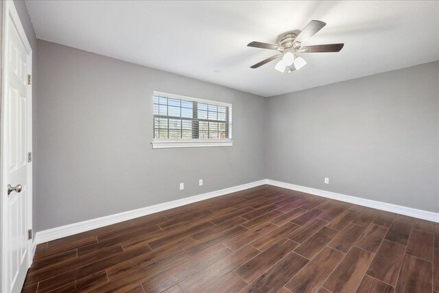 spare room featuring ceiling fan, baseboards, and dark wood-style floors