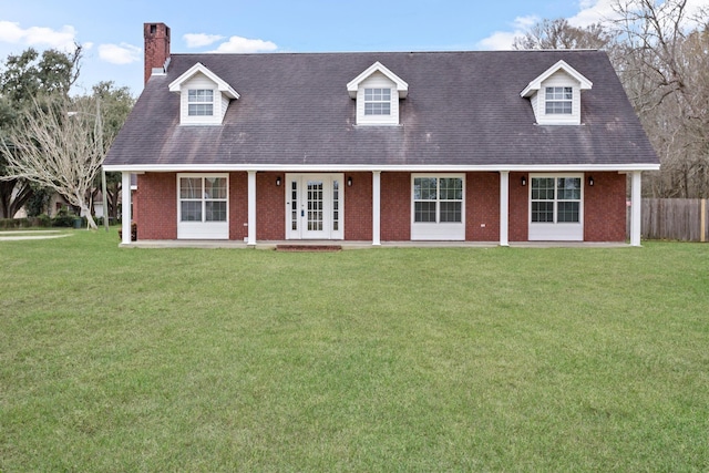 cape cod house with a front yard, brick siding, and a chimney