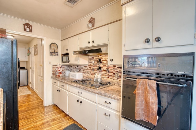 kitchen with white cabinetry, backsplash, ornamental molding, black appliances, and light wood-type flooring