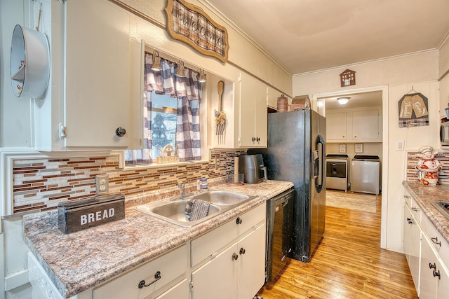 kitchen with sink, washing machine and clothes dryer, and white cabinets