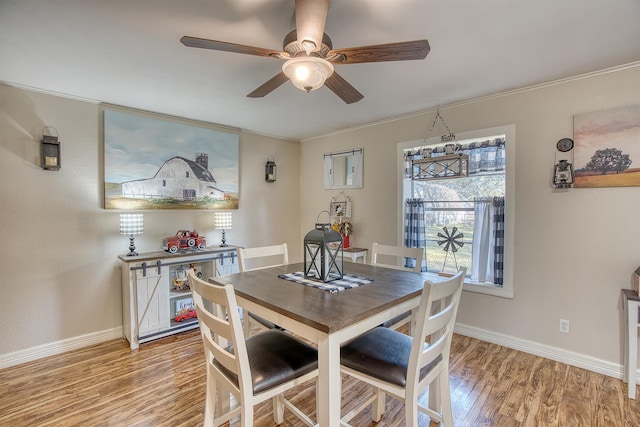 dining room with hardwood / wood-style flooring, ceiling fan, and ornamental molding