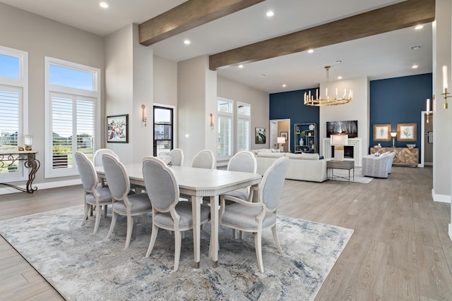 dining room featuring a chandelier, beam ceiling, and light hardwood / wood-style flooring