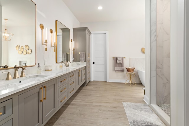 bathroom with vanity, wood-type flooring, plus walk in shower, and a chandelier