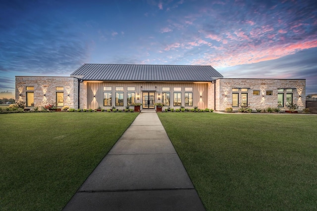 view of front facade featuring french doors and a lawn