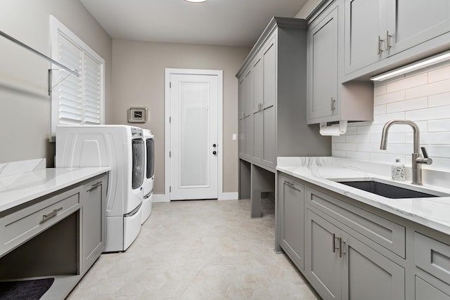 laundry room featuring washer and dryer, cabinets, and sink