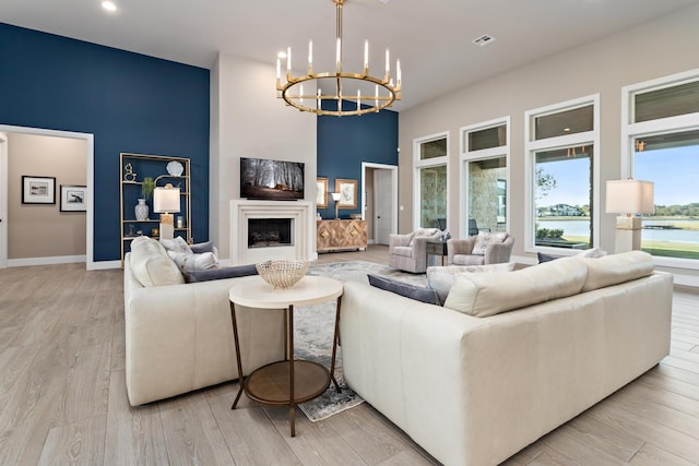 living room with light hardwood / wood-style floors and a notable chandelier