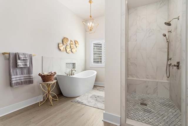 bathroom with hardwood / wood-style flooring, plus walk in shower, and a chandelier