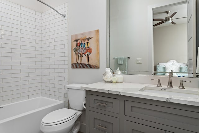 full bathroom with tiled shower / bath, vanity, toilet, and ceiling fan