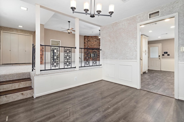 interior space featuring dark hardwood / wood-style flooring and ceiling fan with notable chandelier