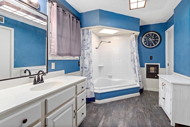 bathroom with hardwood / wood-style floors, shower / bath combo, a textured ceiling, and vanity