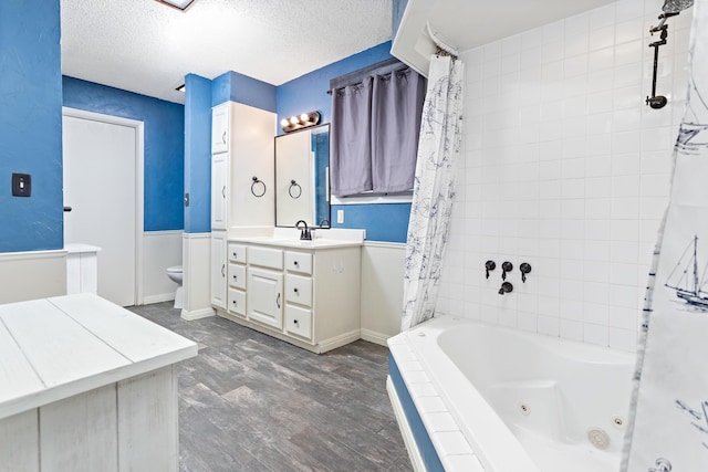 bathroom with vanity, toilet, wood-type flooring, and a textured ceiling