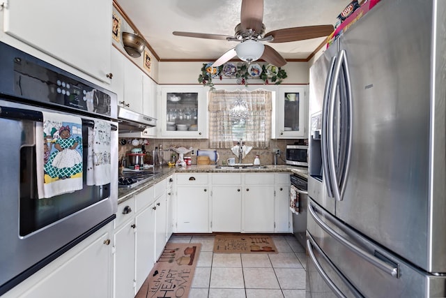 kitchen with sink, decorative backsplash, light tile patterned floors, white cabinetry, and stainless steel appliances