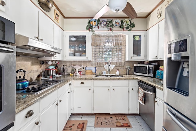 kitchen with white cabinets, appliances with stainless steel finishes, light tile patterned flooring, and sink