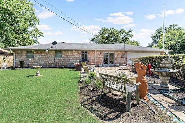 rear view of property with a lawn and a patio