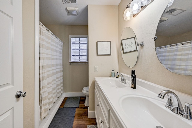 bathroom with hardwood / wood-style floors, vanity, a shower with shower curtain, and toilet