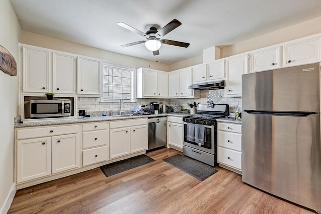 kitchen featuring appliances with stainless steel finishes, light hardwood / wood-style flooring, white cabinetry, and sink