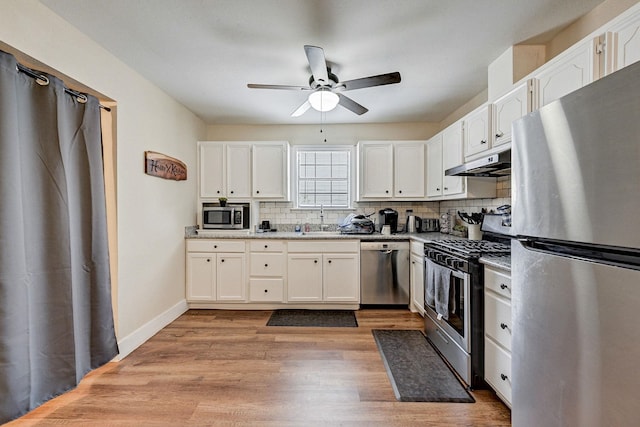 kitchen featuring white cabinets, sink, stainless steel appliances, and light hardwood / wood-style flooring