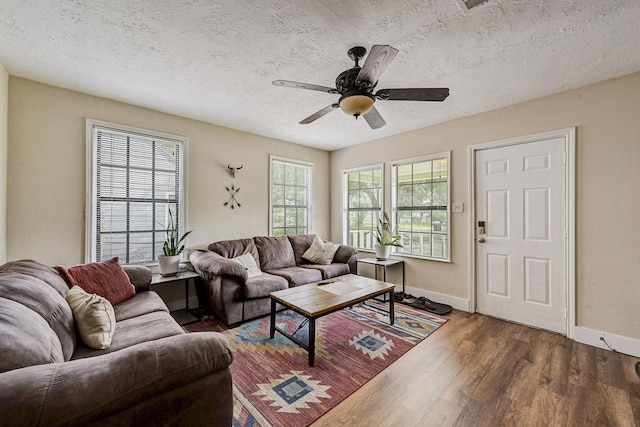 living room with a textured ceiling, hardwood / wood-style flooring, and ceiling fan