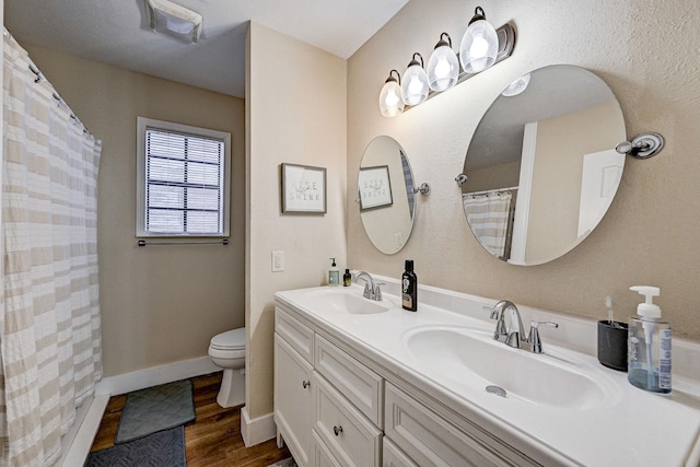 bathroom with vanity, toilet, wood-type flooring, and walk in shower