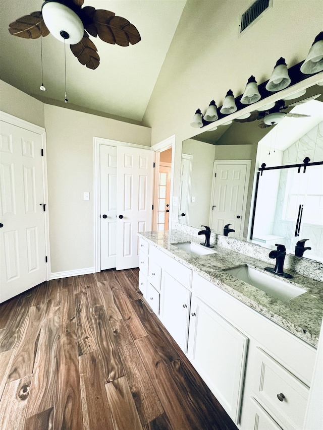 2411 Post Oak Ln, Groves, TX 77619 - full bathroom with lofted ceiling, double vanity, wood finished floors, and a shower with shower door